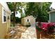 Exterior view of the backyard shed with a white picket fence and mature landscaping at 418 E 10Th Ave, Mount Dora, FL 32757