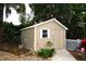 Backyard shed with an adjacent garden and white picket fence at 418 E 10Th Ave, Mount Dora, FL 32757