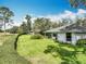 Picture of the backyard that is mostly green grass, a white house, and a small landscape hedge at 42 Grenewood Ln, Haines City, FL 33844
