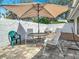Outdoor dining area with patio umbrella, comfortable seating, and privacy wall at 42 Grenewood Ln, Haines City, FL 33844