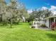 Beautiful backyard featuring a patio, mature trees, and lush landscaping, creating a private outdoor retreat at 42 Grenewood Ln, Haines City, FL 33844