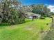 Spacious backyard with lush grass, mature trees, and well-maintained landscaping, offering privacy and serenity at 42 Grenewood Ln, Haines City, FL 33844