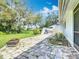 Paver patio area with a grill and seating, surrounded by lush green lawn and mature trees at 42 Grenewood Ln, Haines City, FL 33844