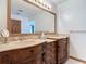 Elegant bathroom featuring a double vanity with decorative wood cabinets, stone countertops, and decorative framed mirrors at 42 Grenewood Ln, Haines City, FL 33844