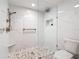 Beautiful walk-in shower with white marble-style tile, mosaic floor, bronze fixtures, and built-in toiletry shelf at 42 Grenewood Ln, Haines City, FL 33844