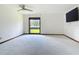 An airy bedroom features neutral carpet, trim, and walls, a ceiling fan, and a window with a backyard view at 42 Grenewood Ln, Haines City, FL 33844