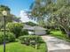 Traditional one-story home with a two-car garage, lush landscaping, and a well-manicured lawn at 42 Grenewood Ln, Haines City, FL 33844