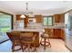 Bright kitchen featuring an island with seating, stainless steel appliances, and wood cabinets with a view of the yard at 42 Grenewood Ln, Haines City, FL 33844