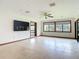 Bright living room with tiled floors, a ceiling fan, large windows and a mounted TV at 42 Grenewood Ln, Haines City, FL 33844
