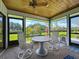 Relaxing screened patio featuring a round table, chairs, and views of the landscaped backyard at 42 Grenewood Ln, Haines City, FL 33844