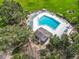 Aerial view of a community pool with many lounge chairs and a nearby pool house surrounded by lush landscaping at 42 Grenewood Ln, Haines City, FL 33844