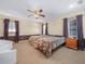 Spacious bedroom featuring carpeting, a ceiling fan, and two beds each with nightstands and lamps at 4333 Shadow Wood Way, Winter Haven, FL 33880