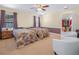 Bright bedroom featuring two beds, carpet, chairs, ceiling fan and access to a walk-in closet at 4333 Shadow Wood Way, Winter Haven, FL 33880