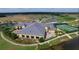 An aerial view showcases the building's architecture, complemented by tennis courts, hot tubs, and lush landscaping at 4480 Turnberry Ln, Lake Wales, FL 33859