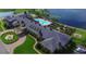 Aerial view of the clubhouse featuring a pool, fountain, lush garden, and covered entrance at 4480 Turnberry Ln, Lake Wales, FL 33859