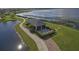 Picturesque aerial view of a screened-in outdoor area nestled by the water with a seating area and walking path at 4480 Turnberry Ln, Lake Wales, FL 33859
