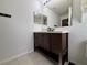 Bathroom featuring a modern vanity with ample storage, neutral tile flooring, and decorative mirrors at 4480 Turnberry Ln, Lake Wales, FL 33859