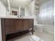 Bathroom featuring a modern vanity with ample storage, neutral tile flooring, and decorative mirrors at 4480 Turnberry Ln, Lake Wales, FL 33859