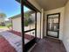 Inviting screened-in front porch with brick flooring and an ornate security door, creating an appealing entrance at 4480 Turnberry Ln, Lake Wales, FL 33859