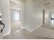 Inviting hallway with tiled flooring leading to a room with a carpeted floor and bright natural light at 4480 Turnberry Ln, Lake Wales, FL 33859