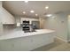 Modern kitchen with white cabinetry, stainless steel appliances, quartz countertops, and tile floors at 4480 Turnberry Ln, Lake Wales, FL 33859