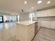Open concept kitchen and living room featuring white cabinets, stainless appliances, and ample counter space at 4480 Turnberry Ln, Lake Wales, FL 33859