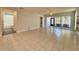 Spacious living room featuring tile flooring, neutral walls, and sliding glass doors to a sunroom at 4480 Turnberry Ln, Lake Wales, FL 33859