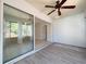 Bright sun room featuring large sliding glass doors, light wood-look flooring, and a ceiling fan at 4480 Turnberry Ln, Lake Wales, FL 33859