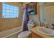 A well-lit bathroom with a shower-tub combo, a toilet, and vanity with a sink at 4703 Benton St, Lake Wales, FL 33859