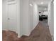 Hallway with carpeted flooring, leading to a living area with black couches at 500 Rio Grande Dr, Kissimmee, FL 34759