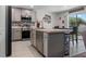 Modern kitchen with stainless steel appliances, stylish backsplash, an island, and a dining area at 500 Rio Grande Dr, Kissimmee, FL 34759