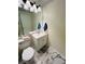 Compact half bathroom features tile floors, white vanity and a large mirror at 502 Little Lake Ct, Winter Haven, FL 33884