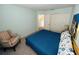 Bedroom featuring a blue quilt bedspread, seating chair, and closet at 502 Little Lake Ct, Winter Haven, FL 33884