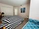 Bright bedroom featuring a bed with striped bedding and a seating nook at 502 Little Lake Ct, Winter Haven, FL 33884
