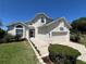 Charming two-story home with attached two car garage, manicured lawn, and mature landscaping at 502 Little Lake Ct, Winter Haven, FL 33884
