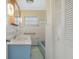 Charming bathroom featuring a blue vanity and a bathtub with unique tiled details at 5829 Lake Breeze Ave, Lakeland, FL 33809