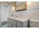 Charming bathroom featuring a marble-painted vanity, tiled walls, and vintage lighting fixtures at 5829 Lake Breeze Ave, Lakeland, FL 33809