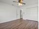 Bright bedroom showcasing wood floors, a ceiling fan, and closet with built-in shelving at 5829 Lake Breeze Ave, Lakeland, FL 33809