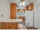Traditional kitchen featuring wood cabinets, white appliances, and a cozy breakfast bar at 5829 Lake Breeze Ave, Lakeland, FL 33809