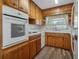 A bright kitchen showcasing wooden cabinets, white appliances, and a window over the sink at 5829 Lake Breeze Ave, Lakeland, FL 33809