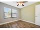 Cozy bedroom with wood-look flooring, a ceiling fan, and a bright window at 6014 Crystal View Dr, Orlando, FL 32819