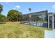 Screened-in pool and patio area surrounded by lush landscaping and a wooden privacy fence at 6014 Crystal View Dr, Orlando, FL 32819