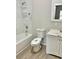 Clean bathroom featuring shower-tub combination, modern vanity, and marble style walls at 602 Nw 1St Ave, Mulberry, FL 33860