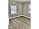 Empty room with modern grey floors, neutral walls, two windows with blinds at 602 Nw 1St Ave, Mulberry, FL 33860
