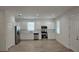 Open kitchen features stainless steel appliances, white cabinets, and luxury vinyl plank flooring at 612 Sears Ne Ave, Winter Haven, FL 33881