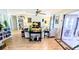 Open-concept living room with light wood floors, a ceiling fan, and abundant natural light at 6305 Bayberry Ne Blvd, Winter Haven, FL 33881
