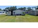 A view of the backyard with green lawn and patio with chairs and table, providing a serene outdoor setting at 6562 Chinaberry Ne Dr, Winter Haven, FL 33881
