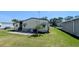 A view of the backyard with green lawn and patio with chairs and table, providing a serene outdoor setting at 6562 Chinaberry Ne Dr, Winter Haven, FL 33881