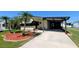 Charming home with a covered carport, complemented by a well-maintained lawn and mature palm trees at 6562 Chinaberry Ne Dr, Winter Haven, FL 33881