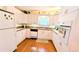 Efficient kitchen with white cabinetry, modern appliances, and hardwood floors at 6562 Chinaberry Ne Dr, Winter Haven, FL 33881
